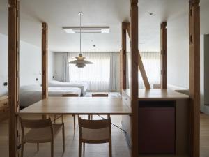 a dining room and living room with a table and chairs at Hotel Miyam Matsubarako in Yanaike