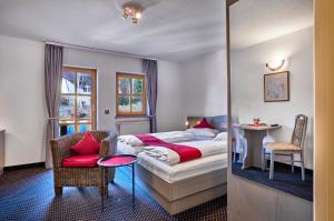 a hotel room with a bed and a chair at Das Arber-Hotel am Rothbach in Bodenmais