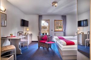 a hotel room with a bed and a desk at Das Arber-Hotel am Rothbach in Bodenmais