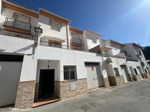 a row of white apartment buildings with a driveway at Nevada Suites Guejar in Güéjar-Sierra