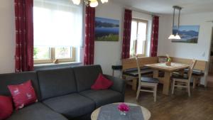 a living room with a couch and a table at Allgaeuer-Landhaus-Stocker in Hopferau