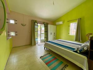 a bedroom with a bed in a room with green walls at Cozy 3BR Duplex with Pool & Garden View - Grand Gaube Getaway in Grande Gaube +19 photos
