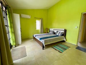 a bedroom with green walls and a bed at Cozy 3BR Duplex with Pool & Garden View - Grand Gaube Getaway in Grande Gaube