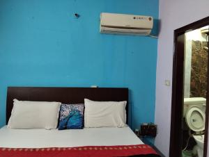 ein Schlafzimmer mit einem Bett, einer blauen Wand und einer Klimaanlage in der Unterkunft Hotel The Height in Chandīgarh + 1 Foto
