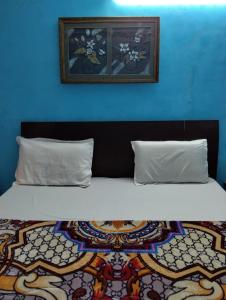 ein Bett mit zwei Kissen und einer blauen Wand in der Unterkunft Hotel The Height in Chandīgarh