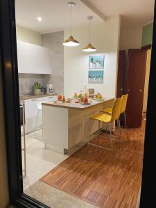 a kitchen with a counter and yellow chairs at Il Piccolo Scrigno 2 in Lonigo