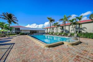 a swimming pool with chairs and a building at Quality Inn Fort Myers Cape Coral in Fort Myers