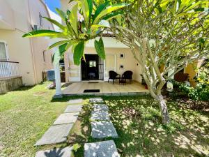 a house with a palm tree in the yard at Cozy 3BR Duplex with Pool & Garden View - Grand Gaube Getaway in Grande Gaube