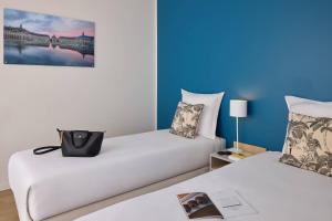 two beds in a room with blue walls at Zenitude Hôtel-Résidences Bordeaux Saint-Jean in Bordeaux +32 photos