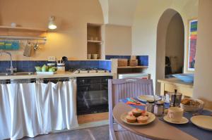 a kitchen with a stove and a table with food on it at Dammuso La Ginestra in Pantelleria