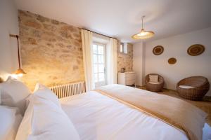 a bedroom with a white bed and a window at Mas Bella Cortis in La Garde-Adhémar