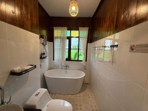 a bathroom with a tub and a toilet and a sink at Shine Villa Sukhothai in Sukhothai +62 photos