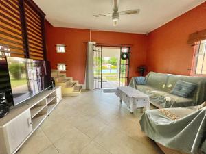 a living room with a couch and a flat screen tv at Cozy 3BR Duplex with Pool & Garden View - Grand Gaube Getaway in Grande Gaube