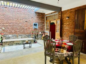 a dining room with a table and a brick wall at Velora Villa Tangalle in Tangalle