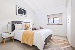a white bedroom with a large bed and a window at SoftPod Loft in Prime Location Fourways in Sandton +19 photos