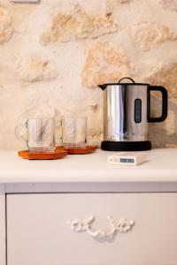 a coffee pot and two glasses on a counter at Mas Bella Cortis in La Garde-Adhémar