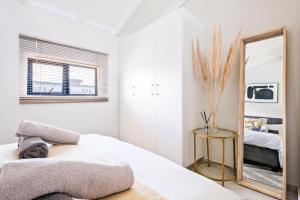 a bedroom with a mirror and a bed at SoftPod Loft in Prime Location Fourways in Sandton