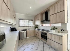 a large kitchen with wooden cabinets and appliances at One Birdswood in Richards Bay