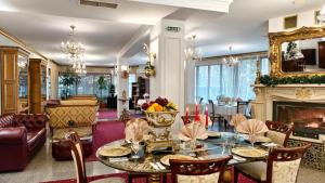 a living room with a table and a fireplace at Elegant Lux Hotel in Bansko