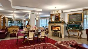 a living room with a table and a fireplace at Elegant Lux Hotel in Bansko
