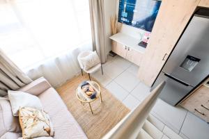 a small living room with a couch and a kitchen at SoftPod Loft in Prime Location Fourways in Sandton