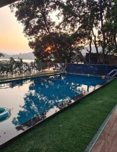 a swimming pool with a reflection in the water at Cape Nirvana, Backwater & Pool villa in Lavasa
