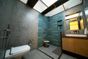a bathroom with a toilet and a sink and a mirror at Cape Nirvana, Backwater & Pool villa in Lavasa +15 photos