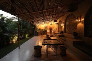 a covered patio with a table and a bench at Cape Nirvana, Backwater & Pool villa in Lavasa