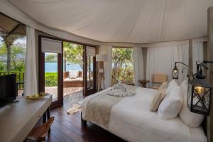 a bedroom with a bed and a view of the ocean at Menjangan Dynasty Resort in Banyuwedang +88 photos