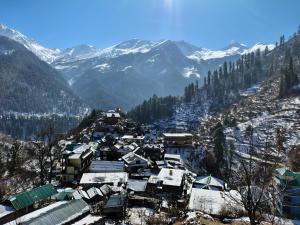 a village in the snow with mountains in the background at Paradise Homestay Tosh in Tosh