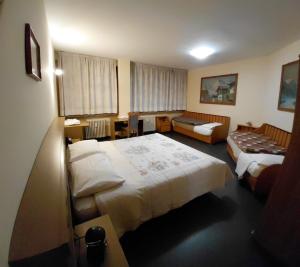 a hotel room with two beds and a couch at Appartamento IN CENTRO a Predazzo in Predazzo