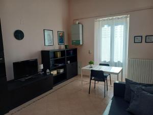 a living room with a table and a television at Corso Ovidio - Casa vacanze in Sulmona