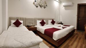 two beds sitting next to each other in a room at Hotel 7heaven in Kānpur