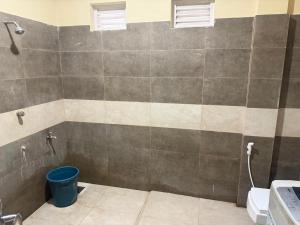 a bathroom with a shower with a bucket in it at Palm Breeze Kokuvil G1 in Jaffna
