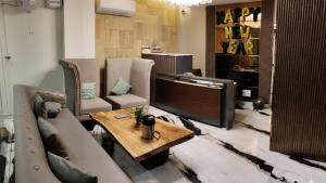 a living room with a couch and a television at Hotel 7heaven in Kānpur