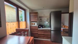 a kitchen with wooden cabinets and a table in a room at Byt v Tatrách in Vysoké Tatry