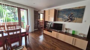 a living room with a dining table and a television at Byt v Tatrách in Vysoké Tatry