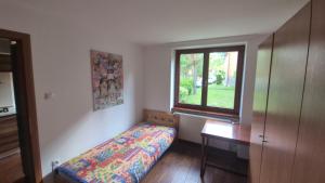 a small bedroom with a bed and a window at Byt v Tatrách in Vysoké Tatry