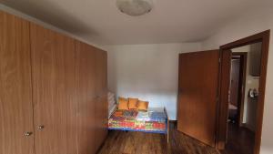 a small bedroom with a bed and a wooden cabinet at Byt v Tatrách in Vysoké Tatry +2 photos