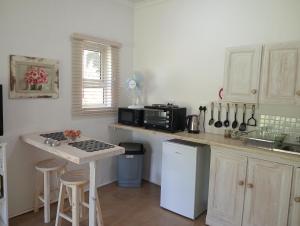a kitchen with a counter with a stove and a sink at Sani's Rest in Himeville