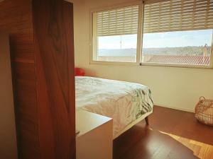 a bedroom with a bed and a large window at LE SITE in Specchia