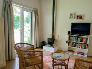 a living room with a tv and a table and chairs at Sani's Rest in Himeville