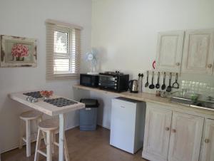 a kitchen with white cabinets and a counter with a stove at Sani's Rest in Himeville +11 photos