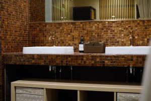 a bathroom counter with two sinks and a bottle of wine at 沐美美藝旅 Mumeimei Artel in Tainan