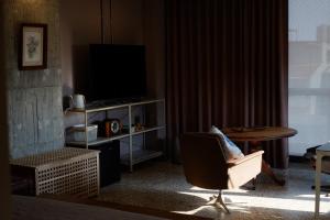 a living room with a chair and a television at 沐美美藝旅 Mumeimei Artel in Tainan +21 photos