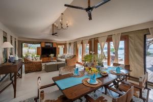 a dining room with a table and a living room at Menjangan Dynasty Resort in Banyuwedang