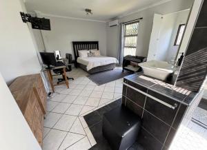 a bathroom with a bed and a sink in a room at One Birdswood in Richards Bay