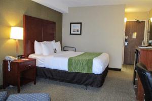 a hotel room with a large bed and a chair at Comfort Inn Dartmouth in Halifax