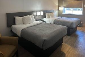 a hotel room with two beds and a couch at Quality Inn Forsyth near GA Public Safety Training Center in Forsyth