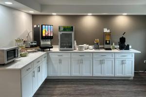 a kitchen with white cabinets and a microwave at Quality Inn Forsyth near GA Public Safety Training Center in Forsyth